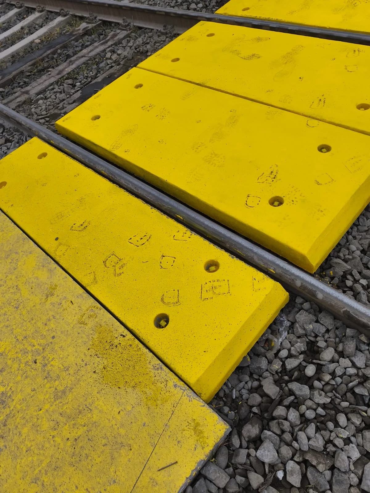 Vista cercana de la superficie texturizada de las losetas instaladas en el cruce ferroviario